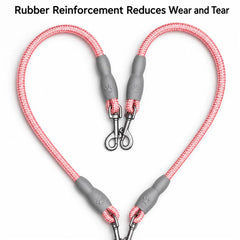 Two pink braided pet leash lines with gray reinforced rubber end caps and metal clip attachments, arranged in a heart shape on a white background with text at the top reading 'Rubber Reinforcement Reduces Wear and Tear'.