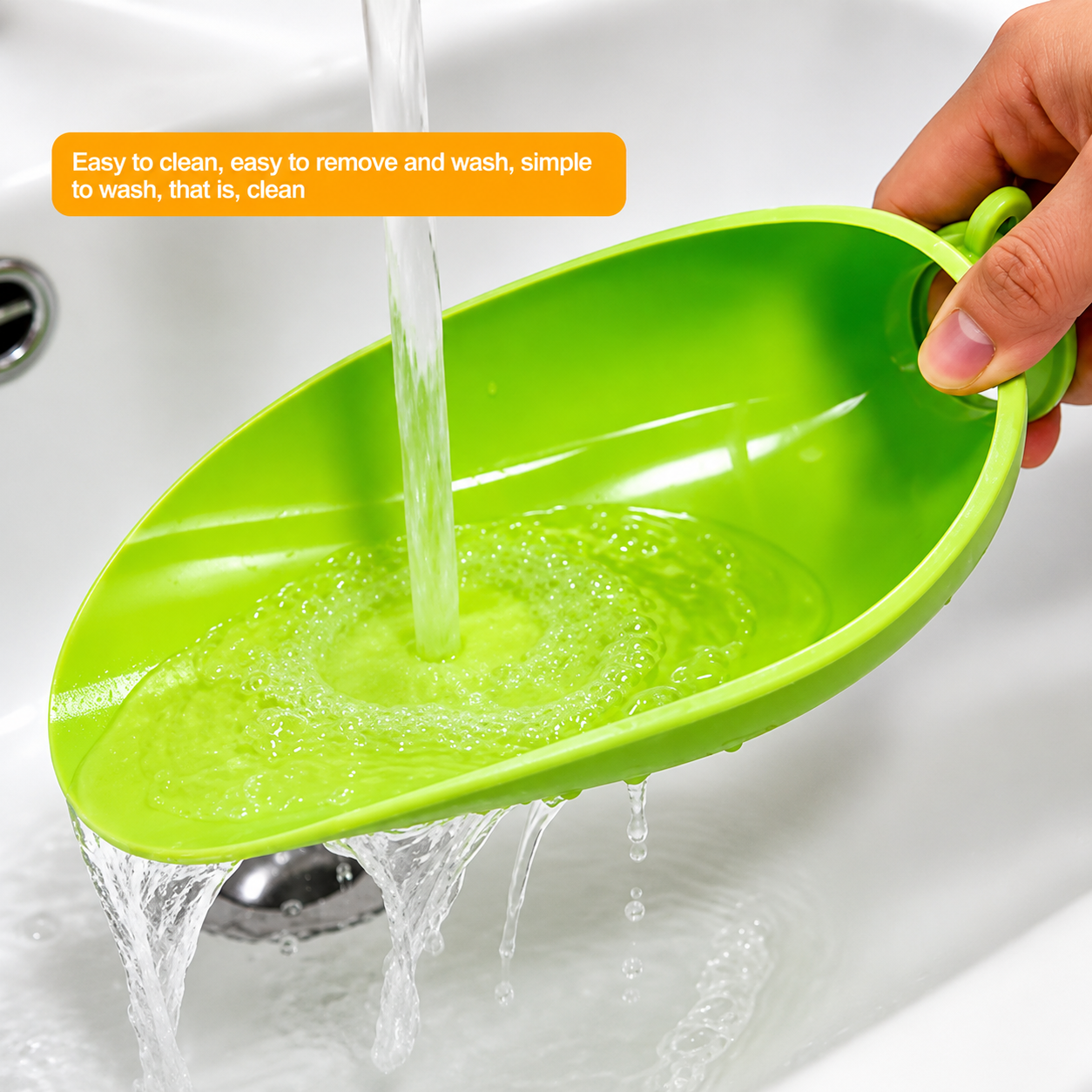 A bright green plastic sink drain strainer held by a hand under running water in a white sink, with an orange text overlay describing its easy-to-clean design.