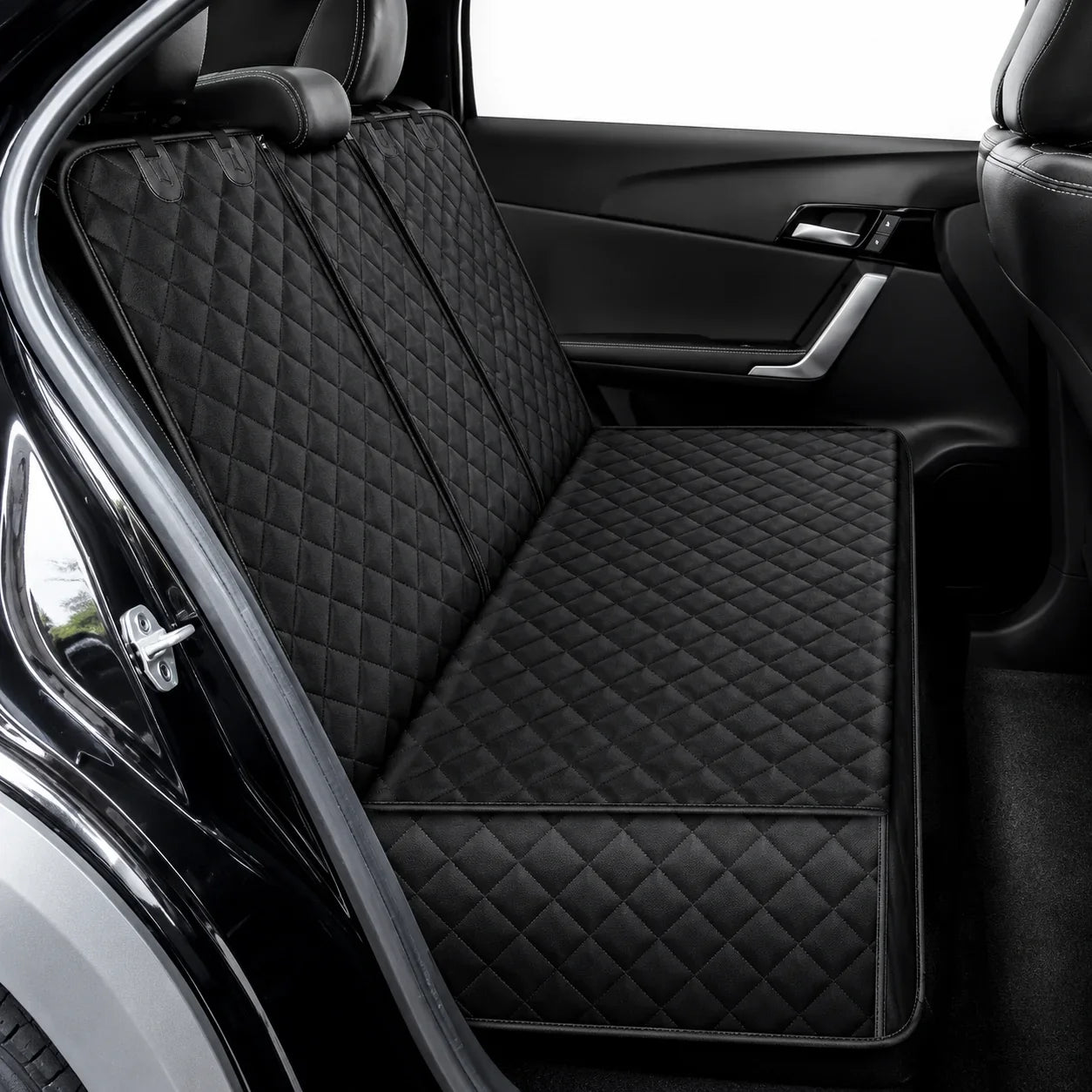 Black quilted car seat liner set installed on a vehicle's front and rear seats, shown from the open rear door.