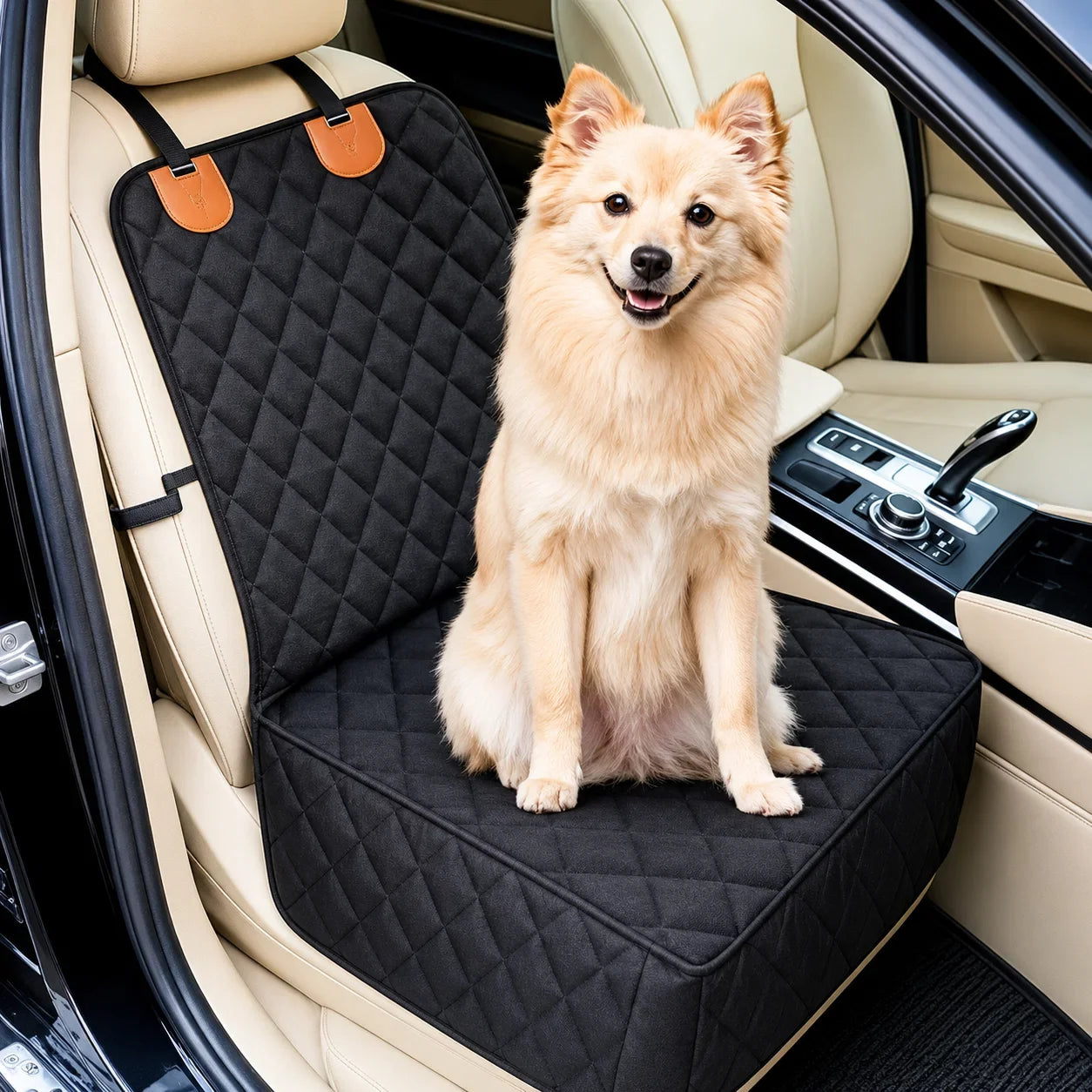 A small fluffy tan dog sits on a black quilted car seat cover installed in a beige car interior.