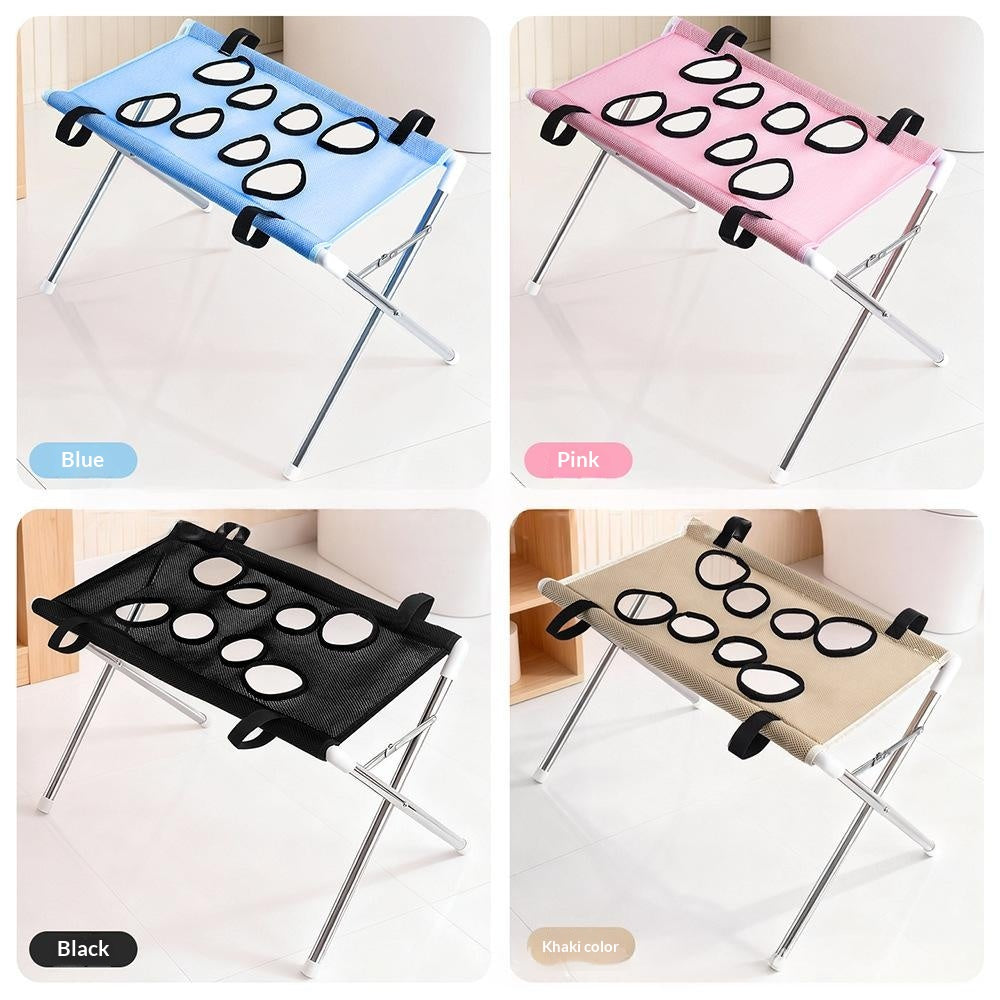 Four color variants of a folding camp stool shown in a 2x2 grid: blue, pink, black, and khaki fabric options with oval cutouts on a silver metal frame. Color labels 'Blue', 'Pink', 'Black', and 'Khaki' appear near each variant.